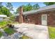 Brick home with a concrete patio and landscaping at 204 Runnymede Ln, Summerville, SC 29485
