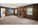 Spacious living room features wood paneling, a cozy brick fireplace, and a mounted television for entertainment at 204 Runnymede Ln, Summerville, SC 29485