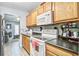 Bright kitchen featuring wood cabinets, black countertops, and a white electric stove at 210 Allen Richard Ct # A&B, Moncks Corner, SC 29461