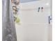 White shower with a gray shower curtain and metal rack with supplies at 210 Allen Richard Ct # A&B, Moncks Corner, SC 29461