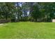 Expansive, level back yard with mature trees provides shade for outdoor activities at 210 Froman Dr, Summerville, SC 29483