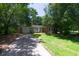 Charming brick home features an attached garage, driveway, and a lush green lawn with mature trees providing ample shade at 210 Froman Dr, Summerville, SC 29483