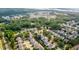 An aerial view captures a scenic community near a marshy landscape and river, surrounded by lush trees at 2242 Dewees Creek Dr, Mount Pleasant, SC 29466