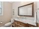 Traditional half bath featuring marble countertop, bronze mirror, and window at 2242 Dewees Creek Dr, Mount Pleasant, SC 29466