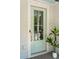 Stylish light blue front door with glass panes, white trim, modern hardware, and a charming potted plant accent at 2242 Dewees Creek Dr, Mount Pleasant, SC 29466