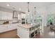 Beautiful kitchen with white cabinets, stainless steel appliances, an island, and modern pendant lighting at 2242 Dewees Creek Dr, Mount Pleasant, SC 29466