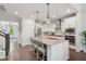 Spacious kitchen with white cabinetry, stainless appliances, a granite island with seating, and stylish pendant lights at 2242 Dewees Creek Dr, Mount Pleasant, SC 29466