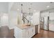 Bright, modern kitchen with stainless steel appliances, an island with bar seating, and stone countertops at 2242 Dewees Creek Dr, Mount Pleasant, SC 29466