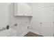Functional laundry room featuring storage cabinets, a utility sink, and modern flooring at 2242 Dewees Creek Dr, Mount Pleasant, SC 29466