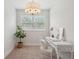 Bright home office features a chandelier, large window, white desk, and decorative plant at 2242 Dewees Creek Dr, Mount Pleasant, SC 29466