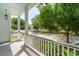 Inviting front porch featuring white railings and a tranquil view of the neighborhood street and lush greenery at 2242 Dewees Creek Dr, Mount Pleasant, SC 29466