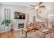 Open-concept living room with a fireplace, fan and view of the staircase at 227 Spectrum Rd, Summerville, SC 29486