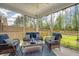 Relaxing screened porch with wicker furniture, a ceiling fan, and a view of the lush backyard at 227 Spectrum Rd, Summerville, SC 29486