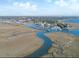 Breathtaking aerial of marshland meeting a quaint coastal town with vibrant waterways and distant ocean views at 231 Bayview Dr, Mount Pleasant, SC 29464