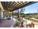 Covered back porch with seating, a fire table, and a view of the marsh and pool at 231 Bayview Dr, Mount Pleasant, SC 29464
