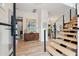 A bright entryway with light wood floors, a floating staircase, and a decorative cabinet at 231 Bayview Dr, Mount Pleasant, SC 29464