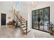 Bright foyer with light wood floors, floating stairs, and a modern black front door at 231 Bayview Dr, Mount Pleasant, SC 29464