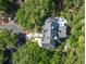 Stunning aerial view of a home nestled among trees, showcasing its unique roof and outdoor deck area at 24 Beachwood West, Isle of Palms, SC 29451
