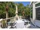 Charming back deck featuring a dining table and lounge seating, surrounded by trees at 24 Beachwood West, Isle of Palms, SC 29451