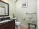 Well-lit bathroom featuring a dark vanity, decorative mirror, and neutral-colored walls at 24 Beachwood West, Isle of Palms, SC 29451