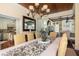 Dining room with wood ceiling, chandelier, floral centerpiece and connection to other living areas at 24 Beachwood West, Isle of Palms, SC 29451