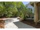 Gravel driveway leading to a charming home, surrounded by lush greenery and trees at 24 Beachwood West, Isle of Palms, SC 29451
