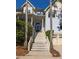 Charming two-story home with a grand front entrance, featuring a beautiful staircase and well-manicured landscaping at 24 Beachwood West, Isle of Palms, SC 29451