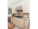 Close-up of modern kitchen with stainless steel hood over gas range and granite countertops, with tiled backsplash at 24 Beachwood West, Isle of Palms, SC 29451