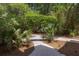Landscaped backyard area with stone path and tropical plants at 24 Beachwood West, Isle of Palms, SC 29451