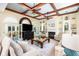 This sun-filled living room features custom built-ins, a fireplace, a large rug, and several seating areas for entertaining at 24 Beachwood West, Isle of Palms, SC 29451