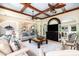 The open-concept living room has a coffered ceiling, hardwood floors, fireplace, built-in shelving, and plenty of seating at 24 Beachwood West, Isle of Palms, SC 29451