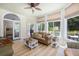 Bright sunroom with a ceiling fan, comfortable seating, and large windows overlooking the outdoor scenery at 24 Beachwood West, Isle of Palms, SC 29451