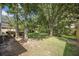 Landscaped backyard featuring a lush lawn, mature trees, and a serene environment at 2418 Castlereagh Rd, Charleston, SC 29414