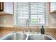 Close up of stainless steel kitchen sink and chrome faucet with a window looking out at 2418 Castlereagh Rd, Charleston, SC 29414