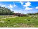 Functional red barn with fenced enclosure, ideal for livestock and other farm animals in a serene country setting at 2470 Breakaway Trl, Johns Island, SC 29455
