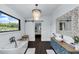 Bright bathroom featuring a freestanding tub, rustic sink, large window, and decorative lighting at 2470 Breakaway Trl, Johns Island, SC 29455
