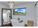 Bright bathroom featuring a freestanding tub, large mirror, and window with a nature view at 2470 Breakaway Trl, Johns Island, SC 29455