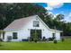 Exterior view of modern farmhouse with a patio and string lights, surrounded by lush green lawn at 2470 Breakaway Trl, Johns Island, SC 29455