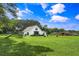 Beautiful modern farmhouse with a playset on a sprawling green lawn and barn, perfect for outdoor activities at 2470 Breakaway Trl, Johns Island, SC 29455