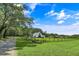 Beautiful exterior of a white farmhouse-style home with a large yard and a tree-lined driveway at 2470 Breakaway Trl, Johns Island, SC 29455