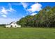 Scenic view of a white farmhouse-style home with a large, well-manicured lawn under a blue sky at 2470 Breakaway Trl, Johns Island, SC 29455