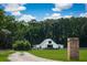 Charming white barn-style home with lush green lawn and mature trees on a sprawling property at 2470 Breakaway Trl, Johns Island, SC 29455