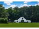 Charming white barn-style home with lush green lawn and mature trees on a sprawling property at 2470 Breakaway Trl, Johns Island, SC 29455