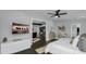 Bright main bedroom with hardwood floors, flat screen tv, ceiling fan, and open view to the living area at 2470 Breakaway Trl, Johns Island, SC 29455