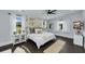 Bright main bedroom featuring a floral accent wall, white bedding, ceiling fan, and ample natural light at 2470 Breakaway Trl, Johns Island, SC 29455
