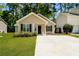 Charming one-story home with manicured lawn and inviting front entrance, complemented by lush surrounding greenery at 258 Trickle Dr, Summerville, SC 29483