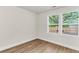 Bright, airy bedroom featuring wood floors, neutral walls, and windows overlooking backyard with fence at 2678 Ranger Dr, North Charleston, SC 29405