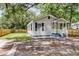 Charming home exterior with gray siding, dark shutters, a yellow door, and a cozy front porch at 2678 Ranger Dr, North Charleston, SC 29405