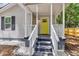 Inviting front porch with bright yellow door, white columns and railings, and attractive landscaping at 2678 Ranger Dr, North Charleston, SC 29405