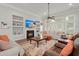 Bright living room with fireplace, built-in shelving, ceiling fan, and hardwood floors at 2772 Latrobe Ct, Mount Pleasant, SC 29466